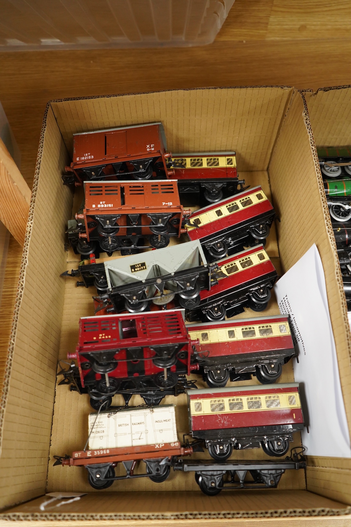 A collection of 0 gauge Hornby tinplate clockwork railway, including four BR locomotives, 17 freight wagons and four wheel coaches, together with a station building, signal cabin, and Goods depot (missing base), plus a f